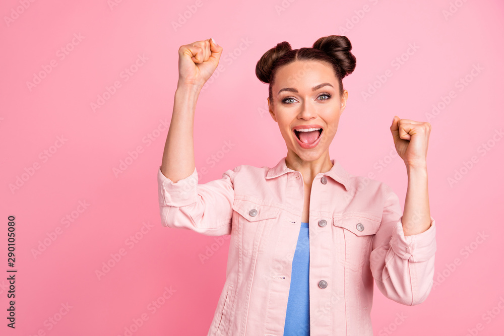 Portrait of enthusiastic woman raising her fists screaming yeah wearing jacket isolated over pink background