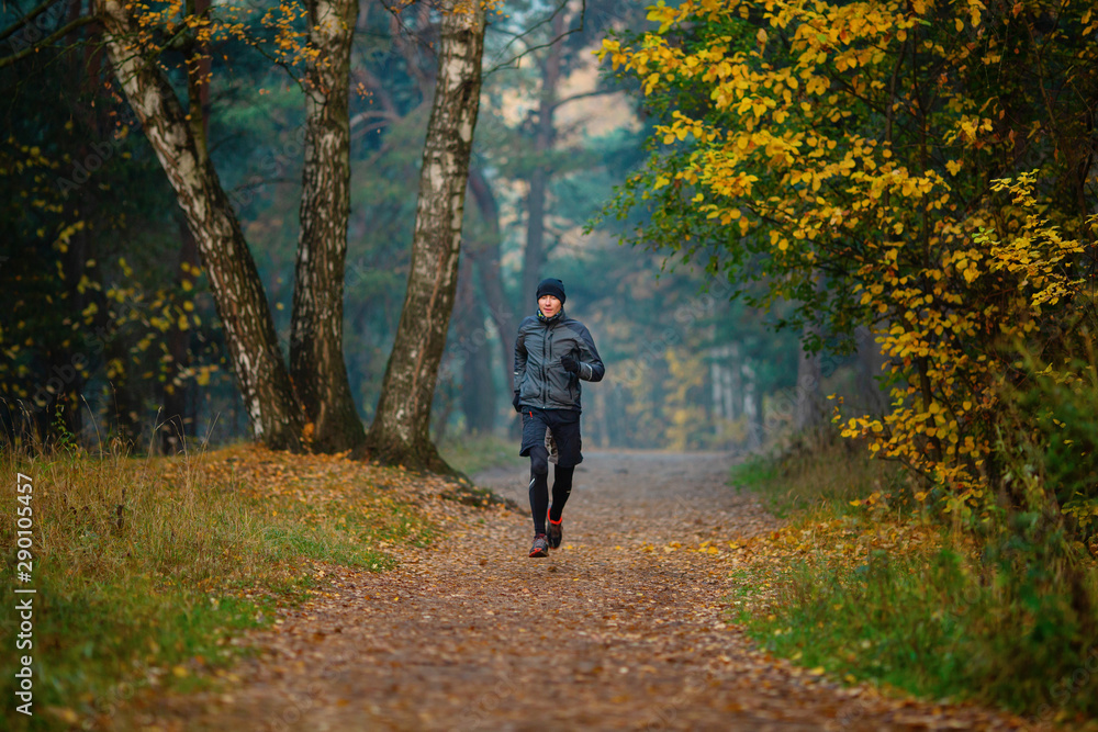 Photo of running athlete in autumn park