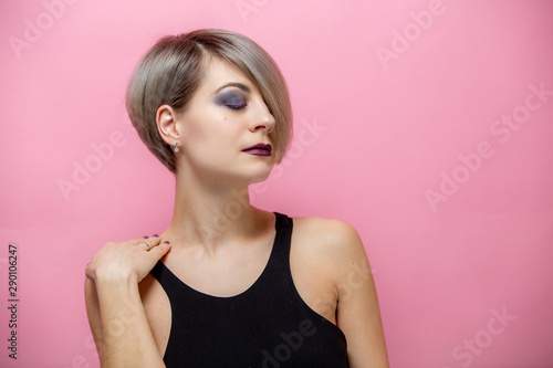  Portrait of young beautiful blonde woman with short hair over pink