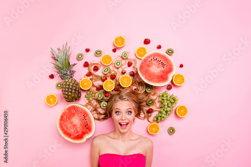 Close up top above high angle view photo beautiful she her lady lying down among different half slices fruits in long volume hair amazing wondered unexpected expression isolated pink background