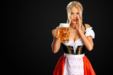 Sexy oktoberfest girl waitress, wearing a traditional Bavarian or german dirndl, serving big beer mug with drink isolated on black background. Woman have a secret.