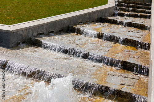 Diagonal view of old grunge stone stairway with water falling down