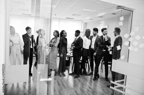 Large group of eleven multiracial business people standing at office. Diverse group of employees in formal wear.