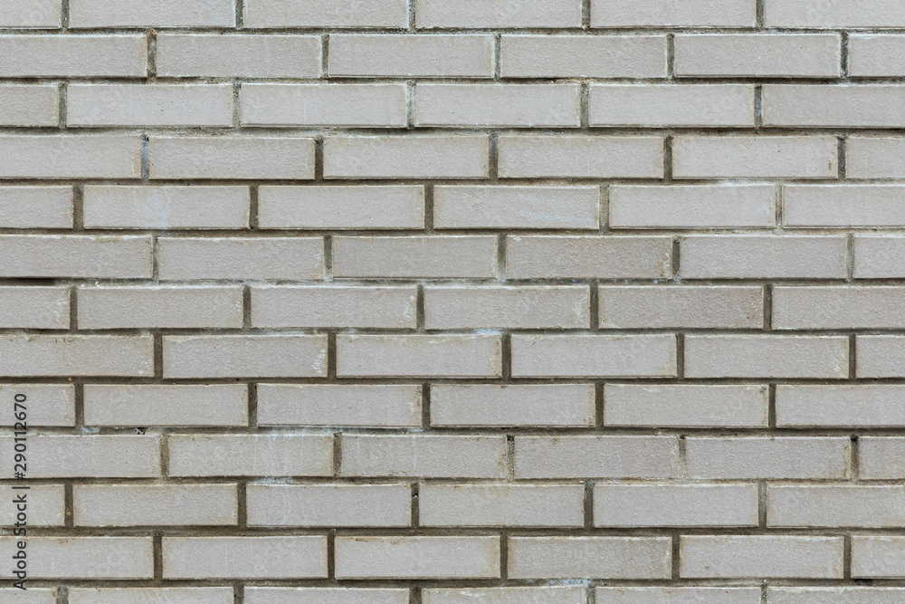 Front view of gray cement wall tiled with brick. Front view of gray cement wall tiled with brick.
