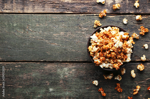 Caramel popcorn in bowl on wooden table