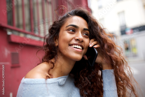 candid portrait of happy young woman talking with mobile phone