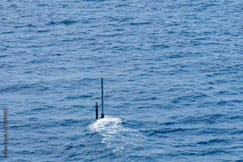 Real periscope and radio transmission mast of the attack submarine  during the submarine sails in the periscope depth in the sea photo