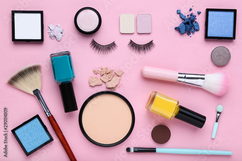 Different makeup cosmetics on pink background