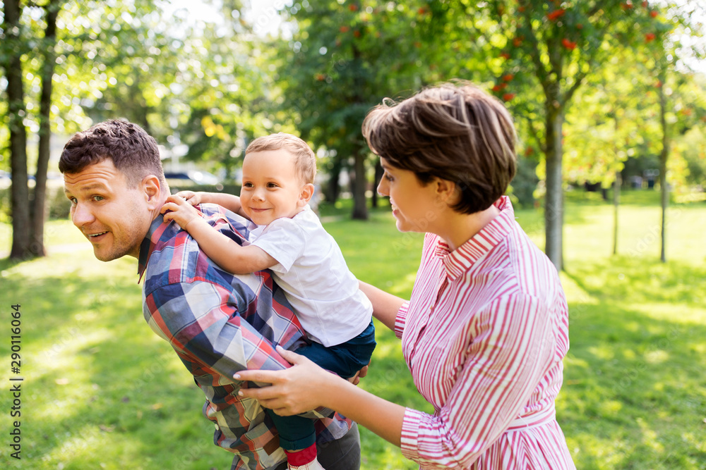 family, leisure and people concept - happy mother, father and little son having fun at summer park family, leisure and people concept - happy mother, father and little son having fun at summer park