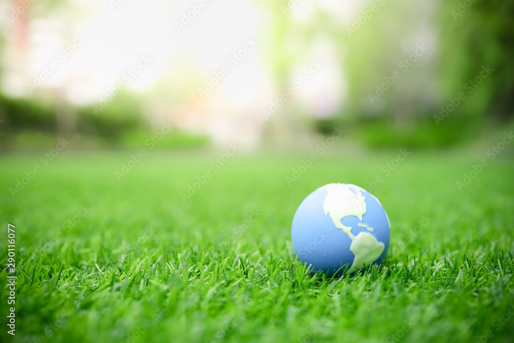 Global Warming, Environment and Ecology Concept. Close up of mini world ball on green grass lawn with rain drop. - obrazy, fototapety, plakaty 