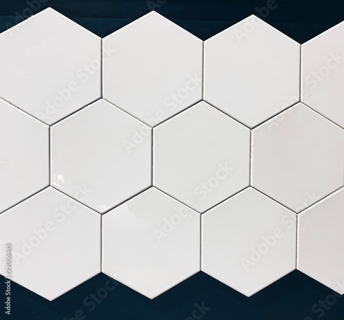 real photo of glossy white hexagonal tiles wall on black background isolated. geometric pattern  abstraction
