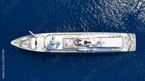 Aerial drone top down photo of luxury yacht with wooden deck cruising the Aegean deep blue sea