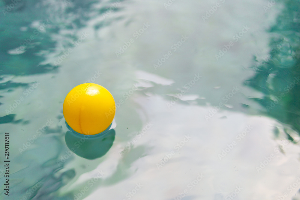 yellow ball floating on the edge of the pool