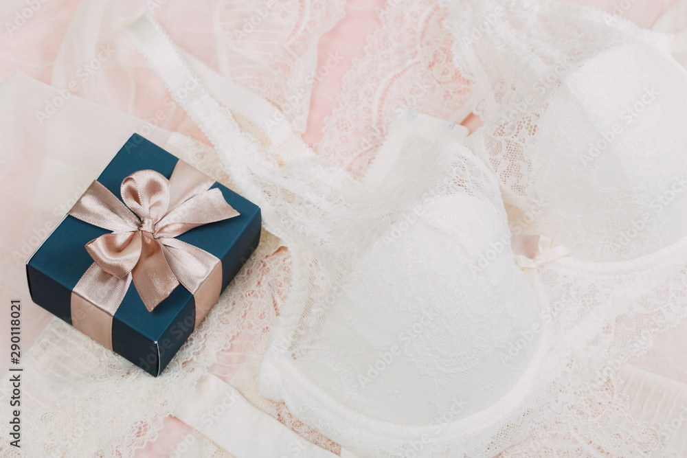 White women underwear with lace and gift box on beige background. white bra and pantie.Copy space. Beauty, fashion blogger concept. Romantic lingerie for Valentine's day temptation. Erotic concept. White women underwear with lace and gift box on beige background. white bra and pantie.Copy space. Beauty, fashion blogger concept. Romantic lingerie for Valentine's day temptation. Erotic concept.