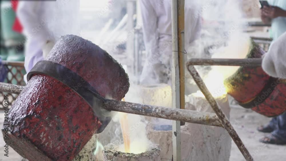 Artisan working gold melting process. Molted metal pouring into bar ...