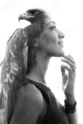 Double exposure portrait of a beautiful young woman gently touching her chin combined with a close up photograph of an exotic eagle, black and white