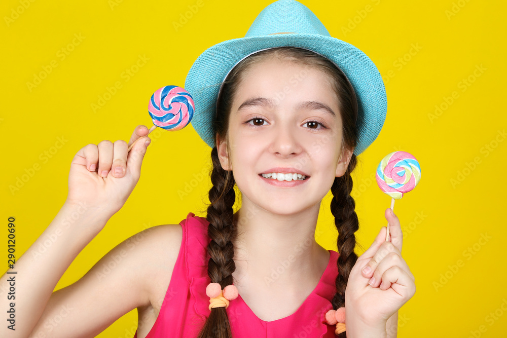 Beautiful young girl with sweet lollipops on yellow background Beautiful young girl with sweet lollipops on yellow background