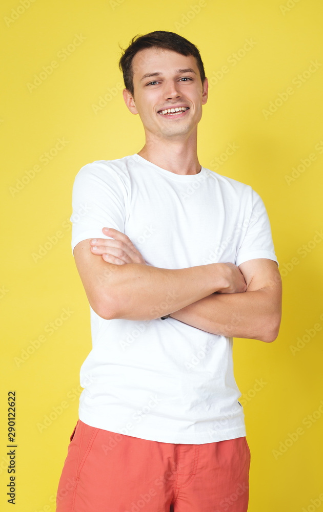 Handsome young man smiling and laughing on yellow background Handsome young man smiling and laughing on yellow background