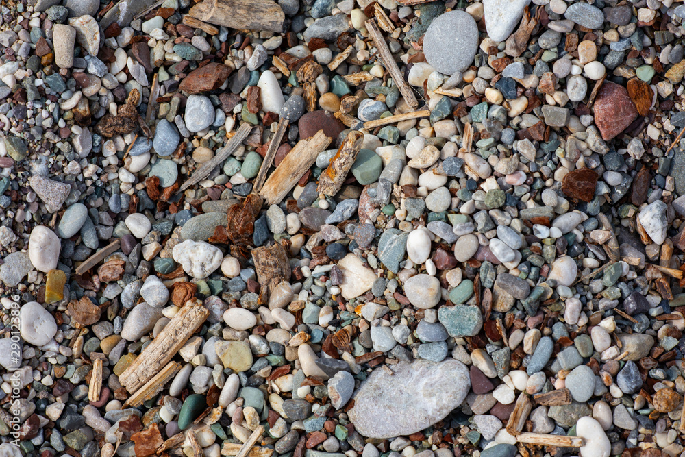Stones texture. Background the damp multi-colored pebbles close up soft focus from on the pebbly beach in cloudy weather. Stones texture. Background the damp multi-colored pebbles close up soft focus from on the pebbly beach in cloudy weather.