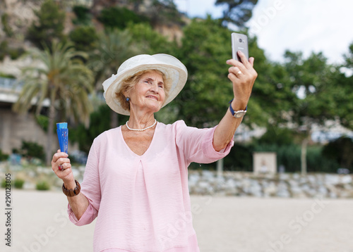 Mature woman taking selfie on beach