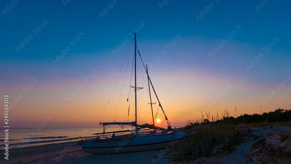 Silhouette of a catamaran in the evening on the seashore