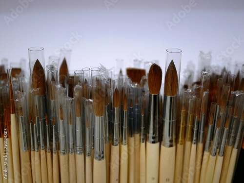 new brushes for painting of different sizes and shapes on display. brushes with wooden handle. goods for artists. products for inks and paints
