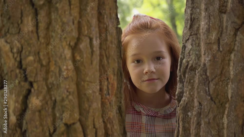redhead child climbing on trees and showing tongue redhead child climbing on trees and showing tongue