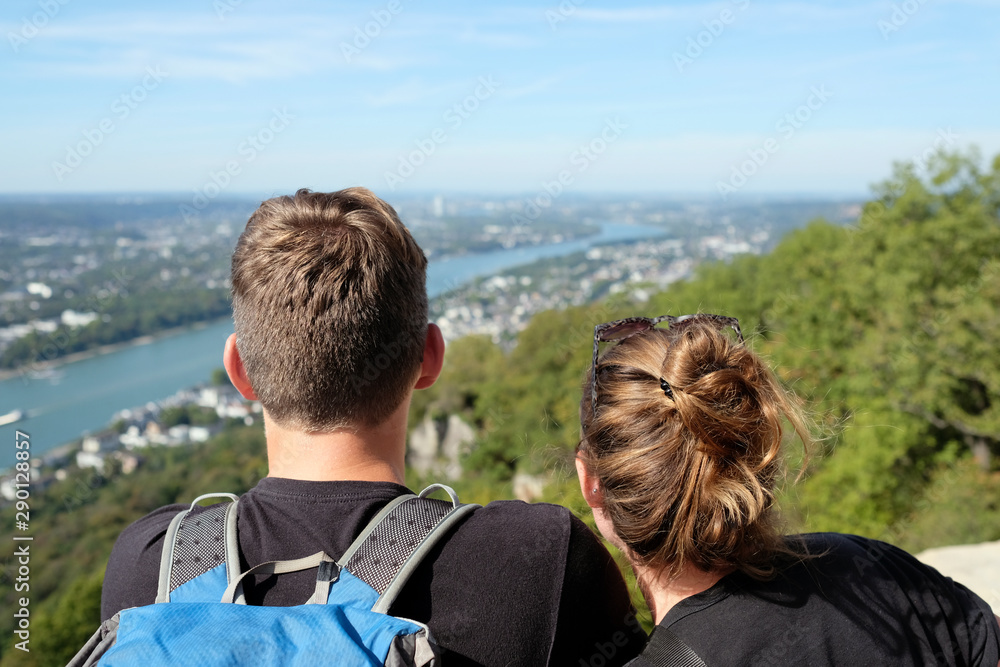 Couple looking towards the horizon next to the river Rhine on a lookout Couple looking towards the horizon next to the river Rhine on a lookout