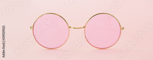 Round hipster sunglasses with pink lenses and golden frame. Fashion accessory for women