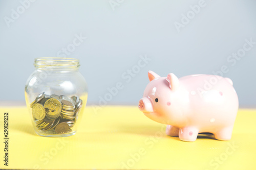 coins on jar with piggy bank