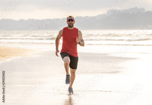 Fitness athlete runner man running and training in sport wear on the beach