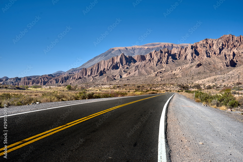 road path between mountains with blue sky