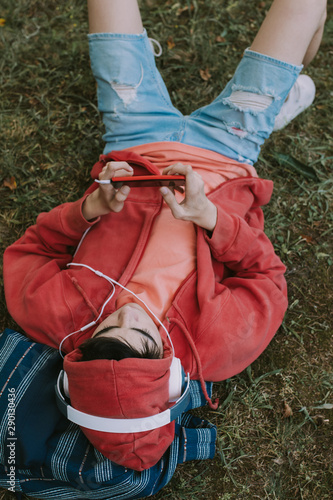 young student in the field with mobile phone and headphones