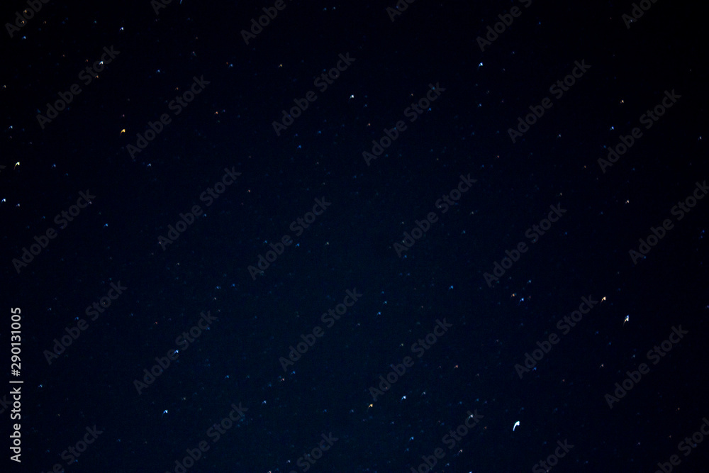 Abstract Long exposure of a clear night sky with shining stars for the background.