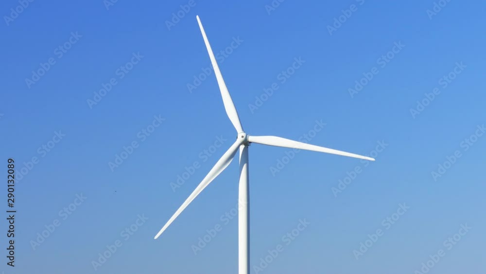 Huge wind generator on blue sky background. Propellers of windmills on blue sky background, close-up Huge wind generator on blue sky background. Propellers of windmills on blue sky background, close-up