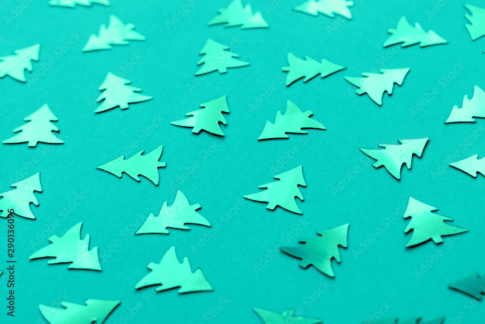 Metallic Christmas trees on a trendy mint green background. Bright turquoise new year's concept. Shiny decorative elements pattern. Metallic Christmas trees on a trendy mint green background. Bright turquoise new year's concept. Shiny decorative elements pattern.