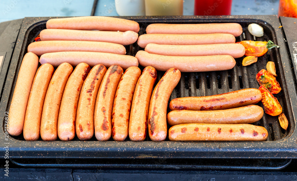 Sausages on a metal grid grilling over hot charcoals Sausages on a metal grid grilling over hot charcoals