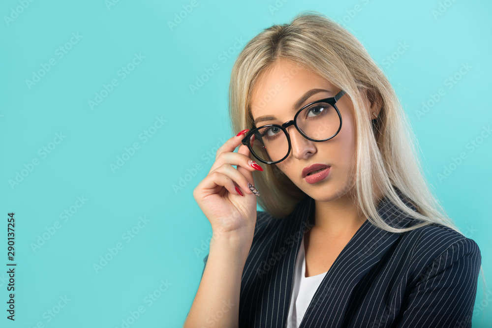 beautiful young woman in a black suit with glasses on a blue background beautiful young woman in a black suit with glasses on a blue background