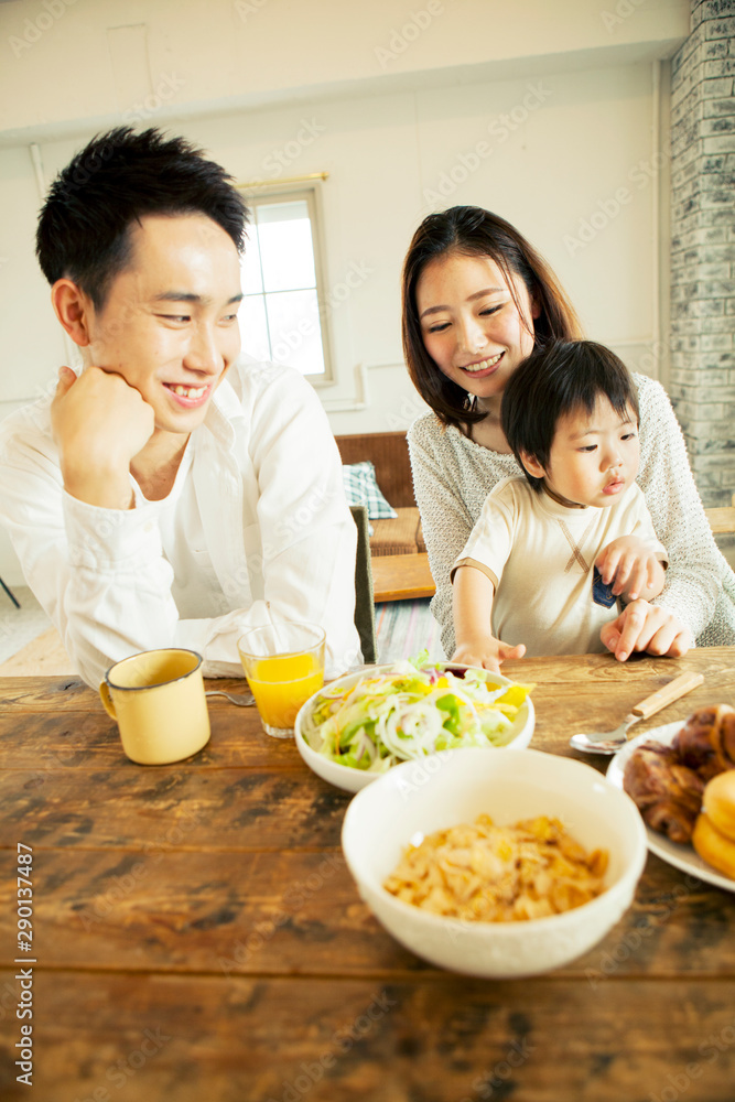 Father smiling while looking at his son at dining table Father smiling while looking at his son at dining table