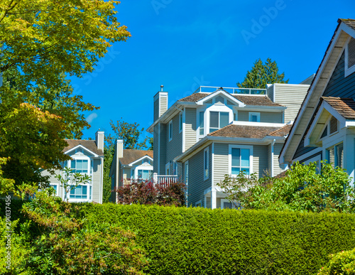 Top of residential townhouses on blue sky background.