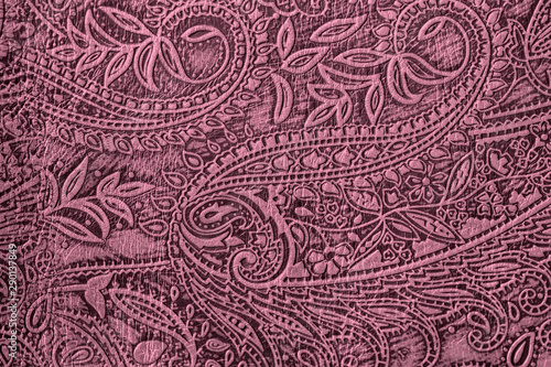 Texture of genuine leather close-up, burgundy purple color with embossed paisley trend pattern, for wallpaper or banner design