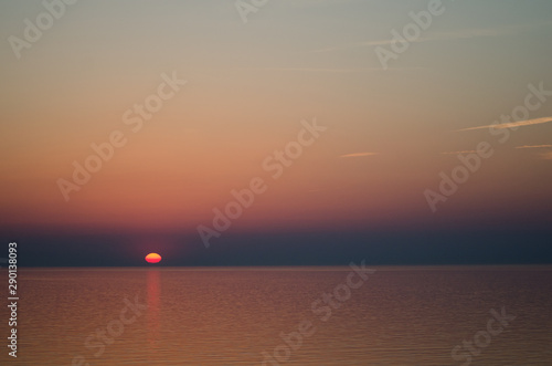 Sunset over sea on orange sky background © Denius