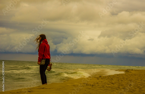Młoda dziewczyna z pieskiem pinczerem nad morzem 