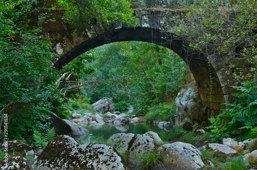 Antique arched stone bridge over Gralheira river in Carvalhais, Sao Pedro do Sul, Portugal photo