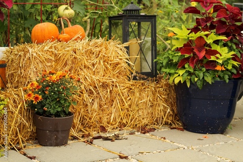 Outdoor Patio decorated for Autumn with pumpkins, pillows, plants and hay bales, lanterns