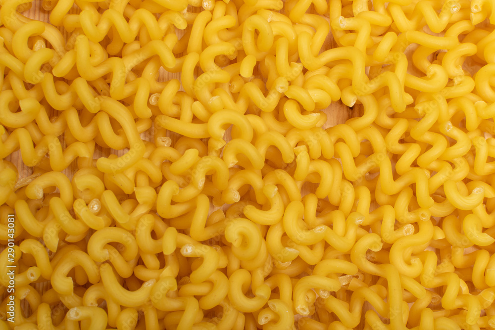 Raw yellow cavatappi pasta texture background top view Raw yellow cavatappi pasta texture background top view