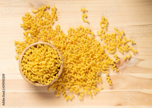 Raw yellow cavatappi pasta on wood table background