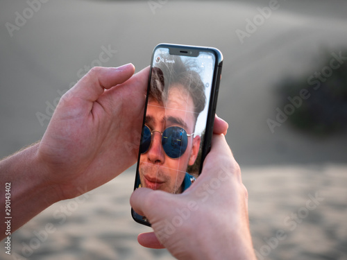 Young male users smartphone to take a selfie
