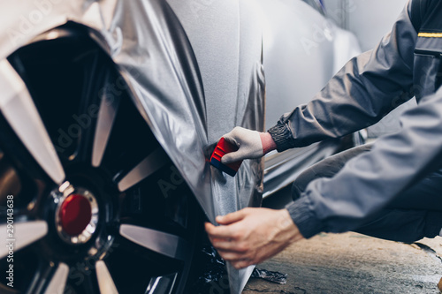Fotografie Car wrapping specialist putting vinyl foil or film on car