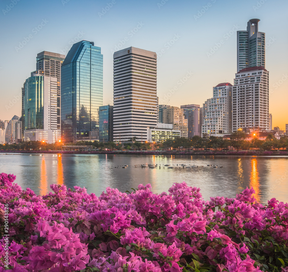 Lake with Purple Flowers in City Park under Skyscrapers at Sunrise. Benjakiti Park in Bangkok, Thailand